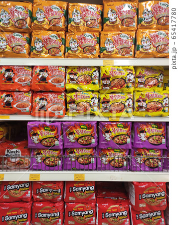 KUALA LUMPUR, MALAYSIA -FEBRUARY 2, 2020: Various brands of instant noodles in a commercial packages stacked for sale on the display shelves in supermarkets.  65417780