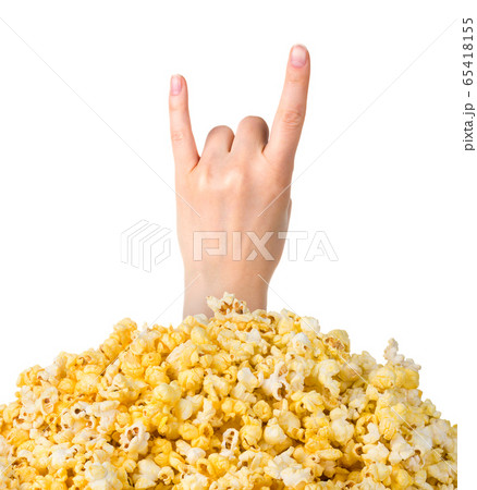 Female hand sticks out of a pile of popcorn isolated on white background Female hand sticks out of a pile of popcorn isolated on white background 65418155