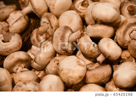 White champignons lie on a store shelf 65420198