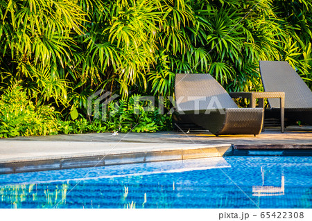 Beautiful outdoor swimming pool with bed deck chair and umbrella in resort for travel and vacation 65422308