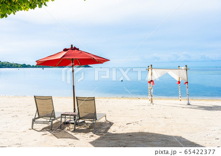 Beautiful outdoor tropical beach sea ocean with umbrella chair and lounge deck around there on white cloud blue sky 65422377