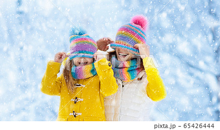 Mother and child in knitted winter hats in snow. Mother and child in knitted winter hats in snow. 65426444