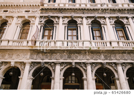 Building Fondazione Musei Civici di Venezia in Venice, Italy. Stone bas-reliefs on the facade of building in Piazza San Marco, classic Venetian windows, columns, balconies with small columns, stucco. 65426680