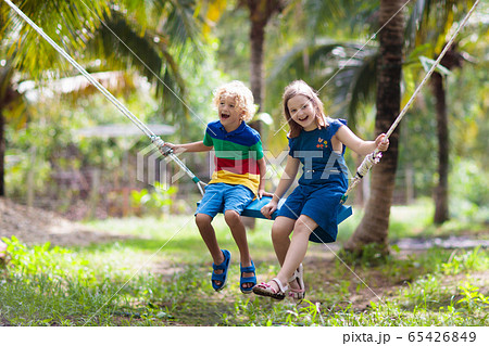 Kids on swing. Playground in tropical resort. Kids on swing. Playground in tropical resort. 65426849