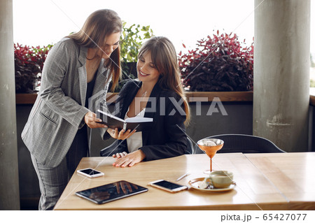 Two businesswomen working in a cafe Two businesswomen working in a cafe 65427077