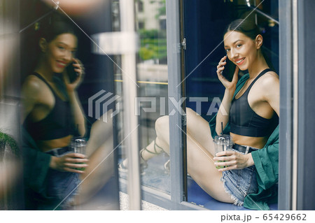Fashion girl standing in a summer cafe Fashion girl standing in a summer cafe 65429662