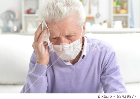 Portrait of sad sick senior man with facial mask 65429877