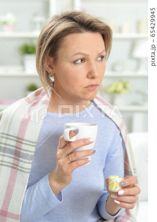 Portrait of beautiful young woman taking pills Portrait of beautiful young woman taking pills 65429945
