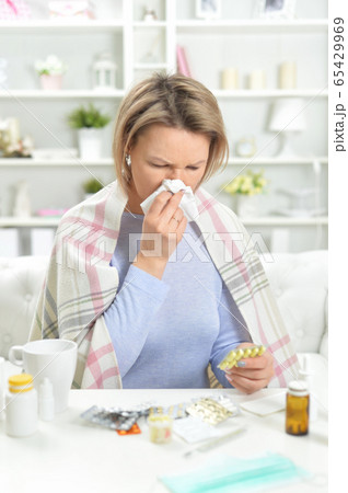 Portrait of beautiful young woman with pills 65429969