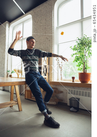Portrait of millenial boy using retro toys, meeting things from the past and having fun, exploring yo-yo game 65434951