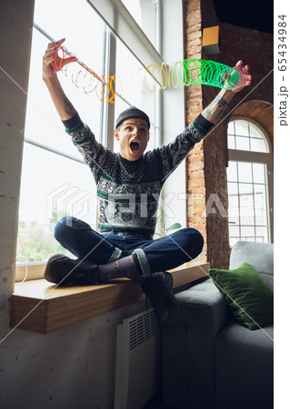 Portrait of millenial boy using retro toys, meeting things from the past and having fun, exploring rainbow spring toy Portrait of millenial boy using retro toys, meeting things from the past and having fun, exploring rainbow spring toy 65434984