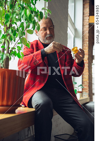 Portrait of senior man with retro toys, meeting things from the past and having fun, exploring the lifestyle of the nineties, playing with yo-yo 65434985