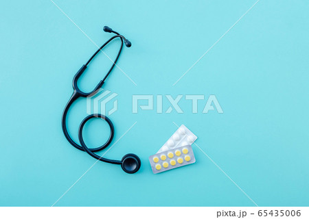 Black modern stethoscope and tablets on light blue background. Black modern stethoscope and tablets on light blue background. 65435006