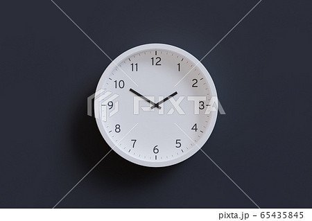 3D Render - White wall clock isolated on dark gray background. Hour hand pointing at 2 and minute hand pointing at 10. 3D Render - White wall clock isolated on dark gray background. Hour hand pointing at 2 and minute hand pointing at 10. 65435845