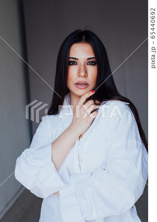 Beautiful fashionable eastern brunette woman in white shirt Beautiful fashionable eastern brunette woman in white shirt 65440692