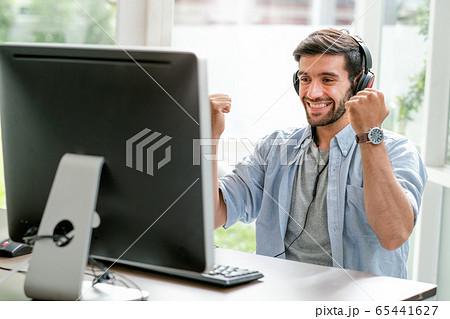 Handsome business man with casual cloth smile and express happy emotion look to monitor of computer 65441627