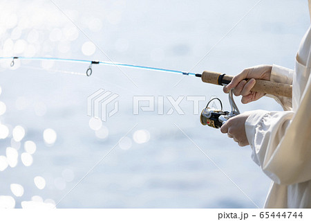 海辺で釣りを楽しむ若い女性 65444744