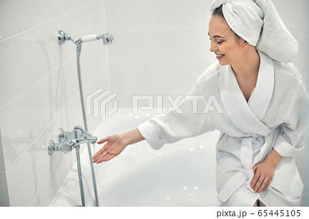 Cheerful lady with white towel on head going to take bath Cheerful lady with white towel on head going to take bath 65445105