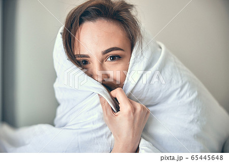 Caucasian cheerful woman hiding under blanket in morning 65445648