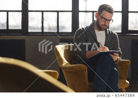 Man writing in document 65447369