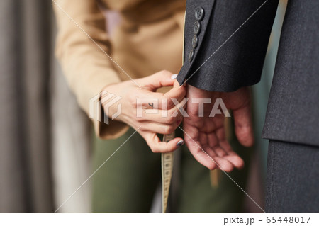 Tailor measuring the sleeve 65448017