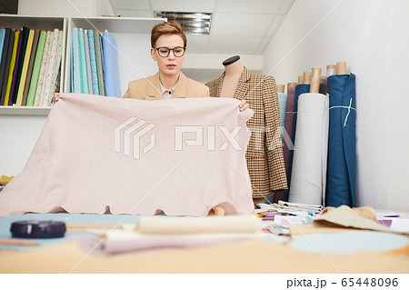 Designer working with fabric for new collection 65448096