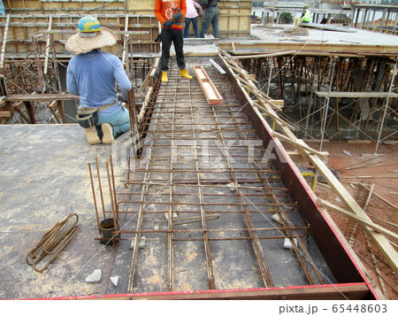 KUALA LUMPUR, MALAYSIA -JULY 14, 2017: Construction workers fabricating steel reinforcement bar at the construction site. The reinforcement bar was tie together using tiny wires.   65448603