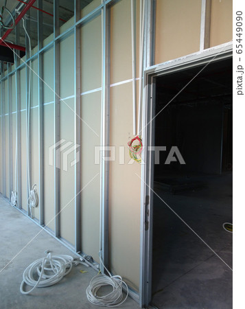 KUALA LUMPUR, MALAYSIA -APRIL 12, 2018: Drywall installation work in progress by construction workers at the construction site. It is the easiest and cheapest way to do partition for an interior wall. KUALA LUMPUR, MALAYSIA -APRIL 12, 2018: Drywall installation work in progress by construction workers at the construction site. It is the easiest and cheapest way to do partition for an interior wall. 65449090