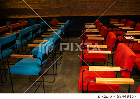 Red and blue chairs in the dark hall of a small 65449157