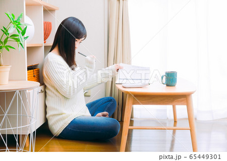 家計簿に記入する女性　考える　手書き家計簿　コピースペース　16:9 65449301