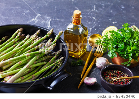 raw green asparagus in black baking dish raw green asparagus in black baking dish 65450440