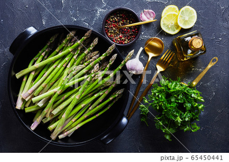 fresh green asparagus in black baking dish 65450441