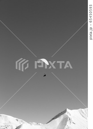 Paraglider in snowy winter mountains at sun day Paraglider in snowy winter mountains at sun day 65450593