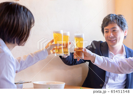 洋風居酒屋で乾杯する男女 65451548