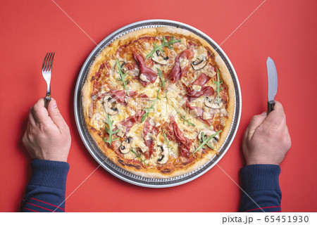 Italian pizza with prosciutto, top view. Man hands 65451930