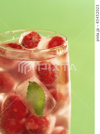 Glass of water with frozen raspberries. Cold Glass of water with frozen raspberries. Cold 65452023