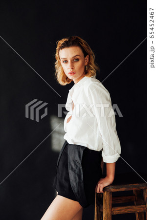 Beautiful fashionable blonde woman in white shirt and shorts Beautiful fashionable blonde woman in white shirt and shorts 65452467