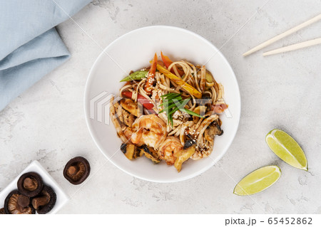 Wok noodles with chicken and shrimp. 65452862