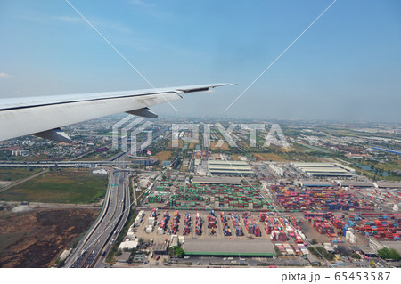 distant landscape against blue sky under airplane wing 65453587