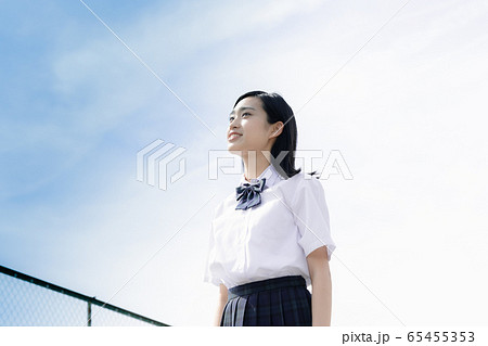 屋上で空を見上げる女子高生 の写真素材