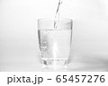 bright water dripping into the glass with many bubble in water bright blue background . healthcare drinking advertising concept  65457276