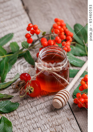 Fresh rose hip berries, rowan and honey on wooden 65460593