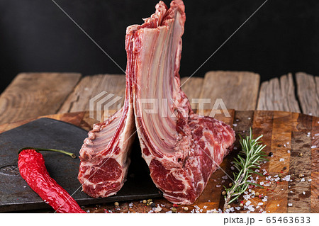 Raw lamb meat in a carnage on wooden background Raw lamb meat in a carnage on wooden background 65463633