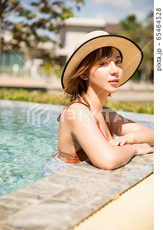 プールサイドでリラックスをする水着姿の女性 65464528