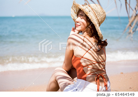 浜辺に座る水着姿の女性 65464549