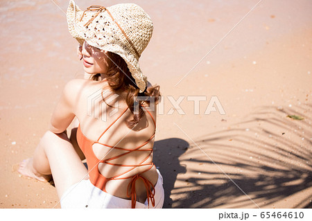 浜辺に座る水着姿の女性 65464610