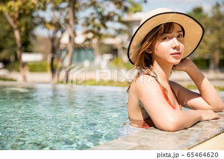 プールサイドでリラックスをする水着姿の女性 65464620