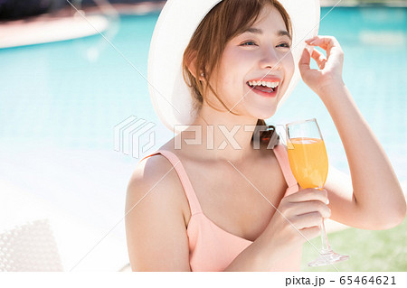 リゾート旅行を楽しむプールサイドの若い女性 リゾート旅行を楽しむプールサイドの若い女性 65464621