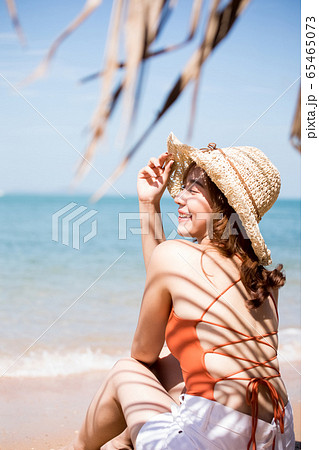 浜辺に座る水着姿の女性 65465073