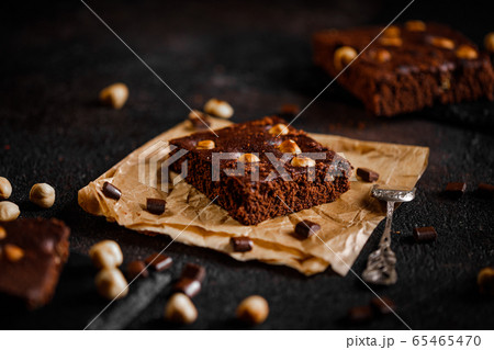 brownie cake wit hazelnut and chocolate on dark grunge table brownie cake wit hazelnut and chocolate on dark grunge table 65465470